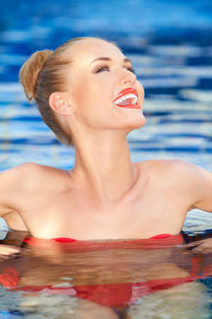 Pretty woman enjoying her time in the water laughing while swimmingの写真素材