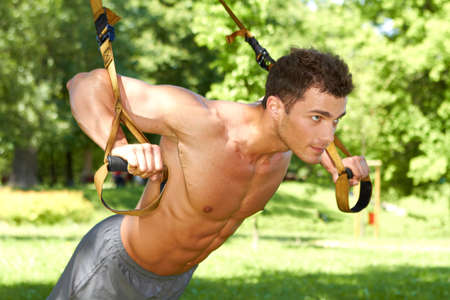 Attractive fittness man doing exercises in parkの写真素材