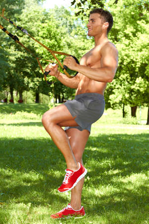 Muscular man doing workout in the parkの写真素材