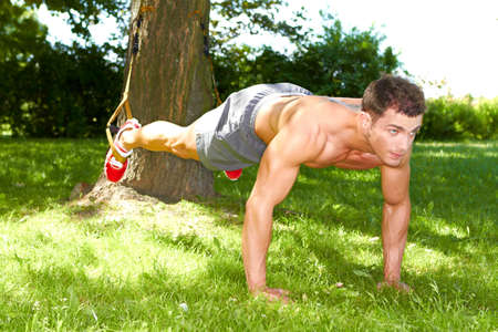 Fitness man doing push ups in the parkの写真素材