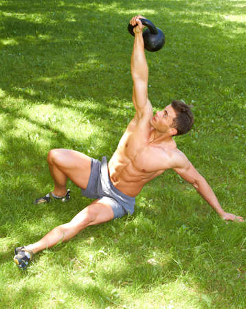 Fitness Man Working with kettlebell at outdoorの写真素材