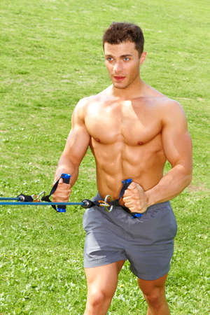 Muscular male doing stretch exercises in parkの写真素材