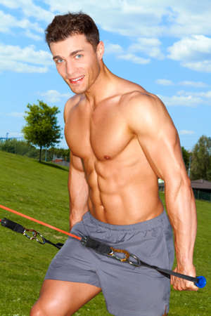 Fitness man doing expand exercises in park at summerの写真素材
