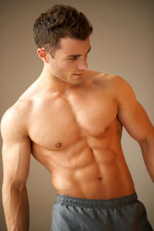 Portrait of a handsome young man with great physique posing on natural backgroundの写真素材