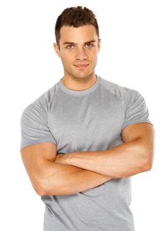 Happy fit male with arms crossed posing over white backgroundの写真素材