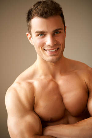 Portrait of smiling man with muscular arms crossedの写真素材