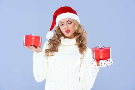Sexy woman in Santa hat trying to decide which gift to chooseの写真素材