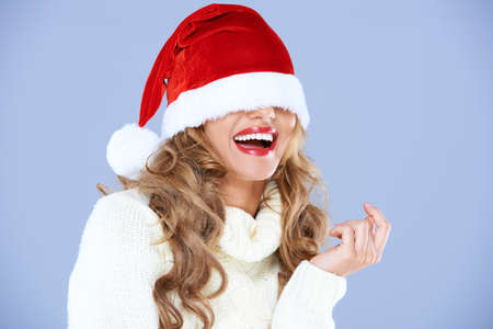 Sexy smiling woman blinded by Red fur Santa hatの写真素材