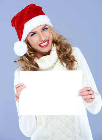 Smiling woman in Santa hat holding blank board with copyspaceの写真素材