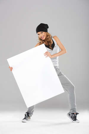 Young fashionable modern dancer holding white empty boardの写真素材