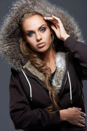 Close up of blond woman wearing hooded sweatshirt on dark backgroundの写真素材