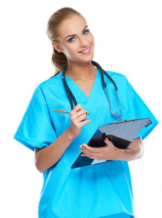 Cute nurse looking at the camera and smiling with writingpad in her handの写真素材