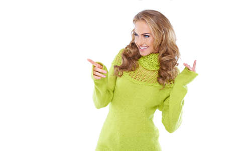 Woman in green sweater pointing out somethingの写真素材