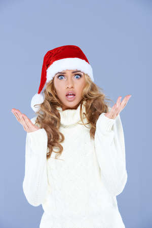 Sexy woman in Santa hat with hands raised, confusedの写真素材