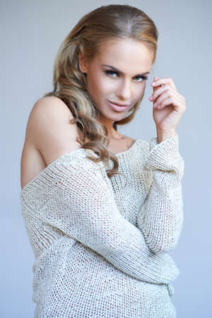 Pretty blonde girl posing while isolated against a grey backgroundの写真素材