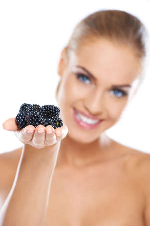 Smiling girl holding blackberries on hand while isolatedの写真素材
