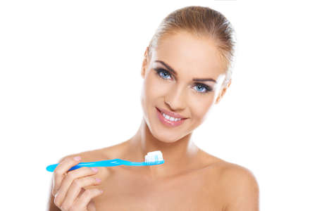Closeup portrait of a happy beautiful woman brushing her teethの写真素材