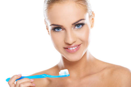 Closeup of beautiful young lady holding toothbrush and smilingの写真素材