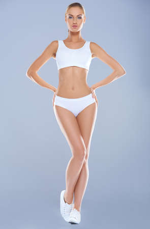 Attractive young woman with perfect body in basic white underwearの写真素材