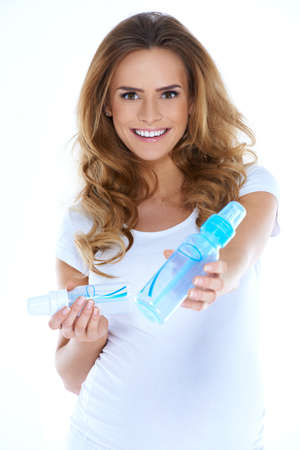 Cute young preganant woman with baby bottles on whiteの写真素材