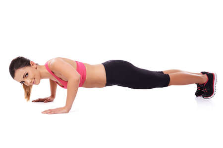 Beautiful fit healthy young woman athlete working out during her training doing press upsの写真素材