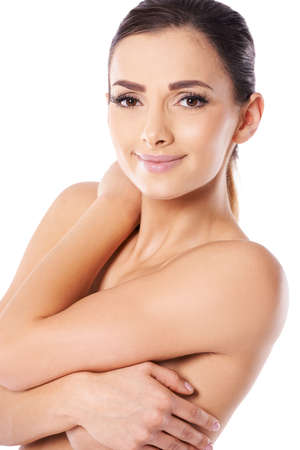 Closeup fresh studio portrait on white of a beautiful naked young woman posing topless smiling at the cameraの写真素材