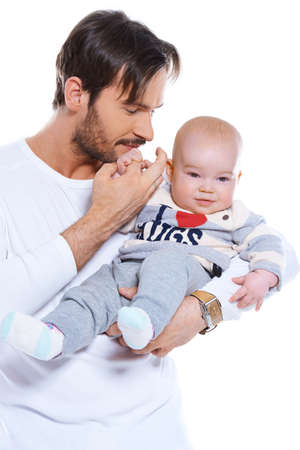 Young loving father cradling his smiling happy baby on his arm, upper body studio portrait on whiteの写真素材
