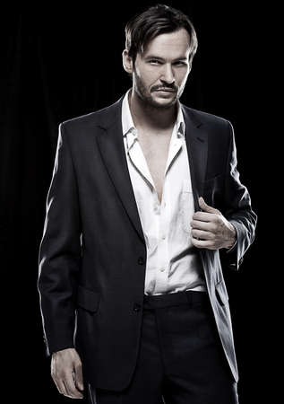 Sexy young Caucasian male beard model wearing a simple and elegant suitの写真素材