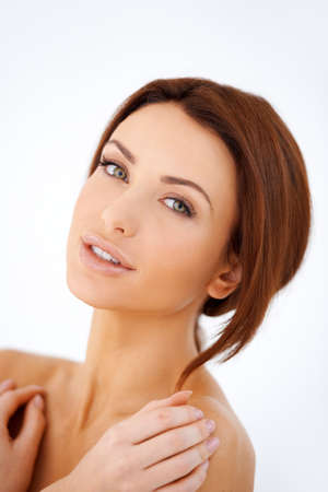 Studio portrait of a beautiful shouldered woman with a lovely natural complexion posing against a white backgroundの写真素材