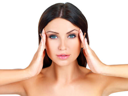 Head and shoulders beauty portrait of a naked beautiful woman massaging her temples with her fingertips isolated on whiteの写真素材