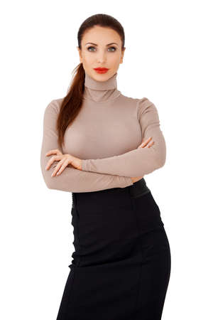 Glamorous brunette lady with her long hair in a ponytail and wearing bright red lipstick standding with folded arms facing the camera isolated on a light grey backgroundの写真素材