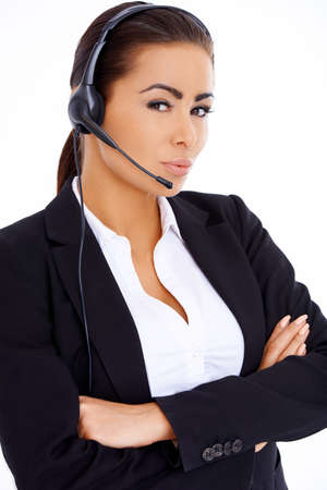 Brunette business woman standing with arms crossed, wearing headsetの写真素材