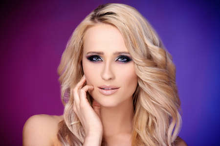 Sensual and glamour portrait of blond woman  she posing over purple and blue backgroundの写真素材