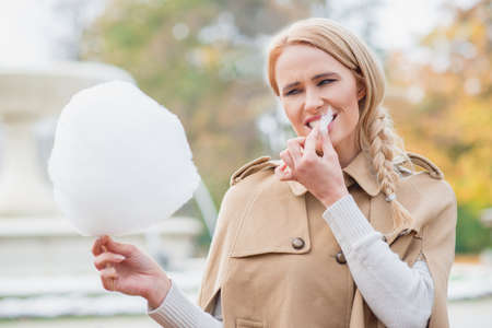 Pretty blond woman eating candy flossの写真素材