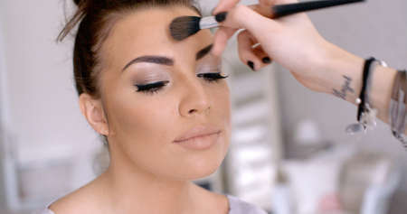 Makeup Artist Applying Lipstick to Pretty Womanの写真素材