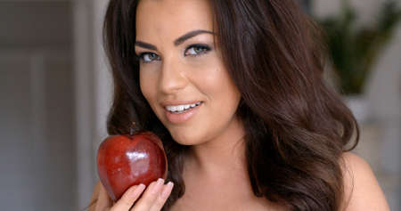 Smiling Pretty Woman Holding Fresh Red Appleの写真素材