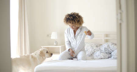 Young woman and her dog resting in bedの写真素材