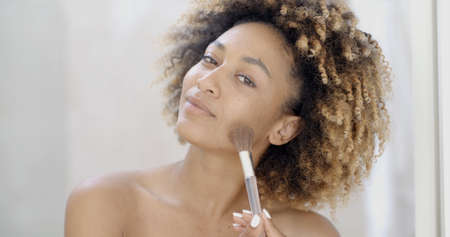 Portrait of young woman causes powder to face