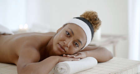 Young african-american woman on massage table in beauty spa salonの写真素材