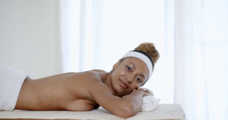 Portrait of a young woman lying on massage table at spa centerの写真素材
