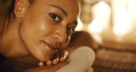 Portrait of a young woman in spa salon lying on the massage deskの写真素材