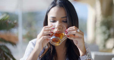 Girl drinking tea from glass cups