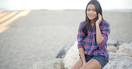 Elegant woman with long hair posing on the summer beach inの写真素材