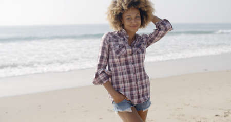 Portrait of a smiling casual young woman standing at the beach