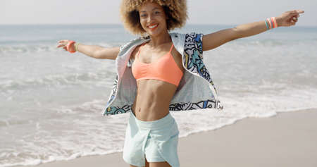 Woman jumping happy on the beach with sea on the background