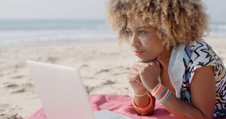 Cute woman with laptop on the summer beach