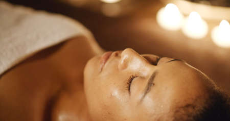African american woman on massage table in luxury spa salon