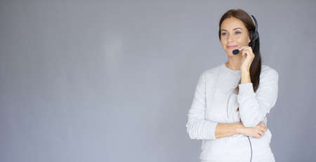 Beautiful and positive female call center agent at work. She speaking with customer using headset....
