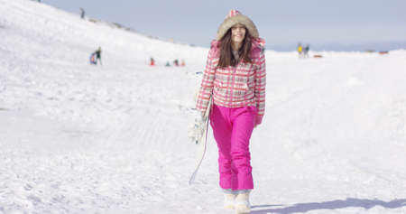 Young woman walking with snowboardの写真素材