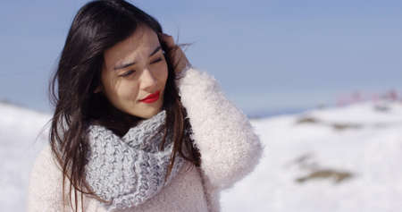 Pretty young woman in sweater on ski slopeの写真素材